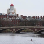 A sculler rows down the Charles River near Harvard University.