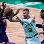 Boston Celtics center Kristaps Porzingis (8) passes the ball while pressured by the New York Knicks during the first half of Game 1 of an NBA basketball second-round playoff series Monday, May 5, 2025, in Boston