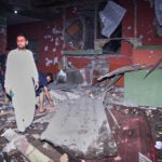 Local residents examine a building damaged from a suspected Indian missile attack near Muzaffarabad, the capital of Pakistan controlled Kashmir, in Wednesday, May 7, 2025.