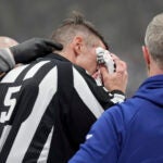 Referee Chris Rooney (5) is tended to as he is escorted off the ice after receiving an injury from being clipped by a player during the first period of Game 7 of a second-round NHL hockey playoff series between the Florida Panthers and the Toronto Maple Leafs in Toronto, Sunday, May 18, 2025.