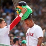 Jarren Duran crowns teammate Rafael Devers with a "Wally the Green Monster" head that the team uses for their celebrations after a home run in the seventh inning as the Red Sox took on the Texas Rangers.