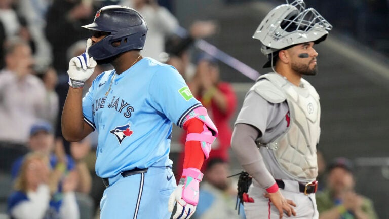 Toronto Blue Jays' Vladimir Guerrero Jr. gestures as he crosses the plate in front of Red Sox catcher Carlos Narvaez after hitting a three-run home run during eighth-inning.