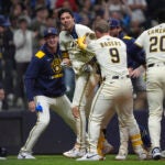 Milwaukee Brewers' Christian Yelich (22) is congratulated by teammates after hitting a walk off grand slam during the 10th inning of a game against the Red Sox.