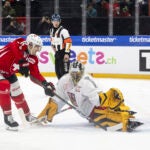 Switzerland's Fabrice Herzog, left, in action against Czechia's goalkeeper Simon Zajicek, during the Euro Hockey Tour match between Czechia and Switzerland, at the BCF Arena in Fribourg, Switzerland, Saturday, Dec. 14, 2024.