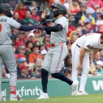 Red Sox pitcher Justin Slaten reacts as Twins shortstop Carlos Correa high-fives Trevor Larnach after scoring during the eighth inning.