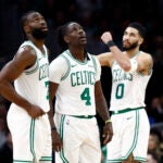 Boston Celtics Jaylen Brown (7), Jrue Holiday (4) and Jayson Tatum (0) react to Holiday drawing a foul during the fourth quarter at TD Garden.