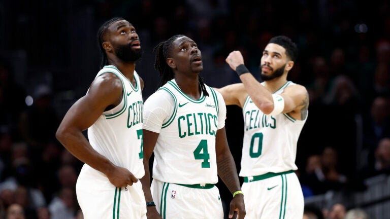 Boston Celtics Jaylen Brown (7), Jrue Holiday (4) and Jayson Tatum (0) react to Holiday drawing a foul during the fourth quarter at TD Garden.