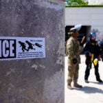 DHS police and National Guard protect the outside the Metropolitan Detention Center.