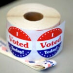 FILE - A spool of stickers rests on a table at a polling station during Massachusetts state primary voting, Sept. 3, 2024, in Newton, Mass.