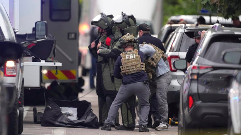 Law enforcement officials dress in protective gear to investigate after an attack on the Peark Street Mall Sunday, June 1, 2025, in Boulder, Colo.