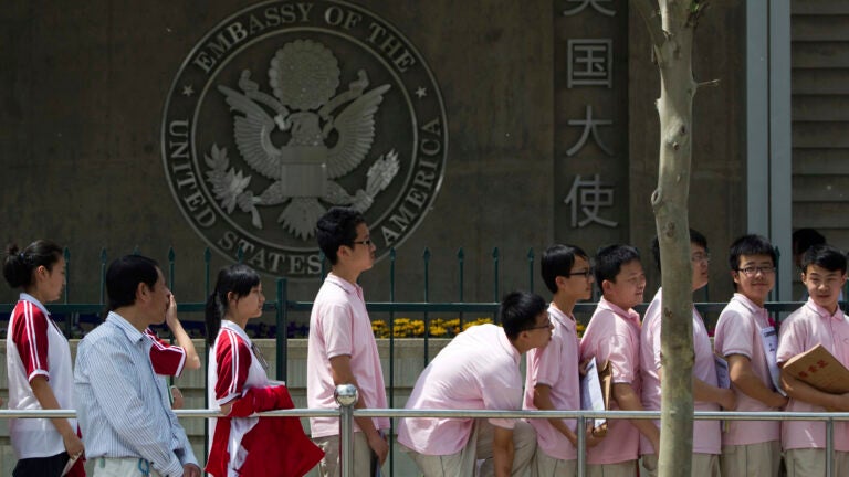FILE - Chinese students wait outside the U.S. Embassy for their visa application interviews, in Beijing on May 2, 2012.