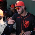 San Francisco Giants' Bryce Eldridge skakes hands with a teammate in the dugout prior to a spring training baseball game against the Chicago Cubs Wednesday, Feb. 26, 2025, in Scottsdale, Ariz.