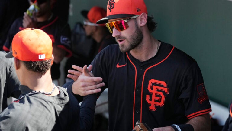 San Francisco Giants' Bryce Eldridge skakes hands with a teammate in the dugout prior to a spring training baseball game against the Chicago Cubs Wednesday, Feb. 26, 2025, in Scottsdale, Ariz.
