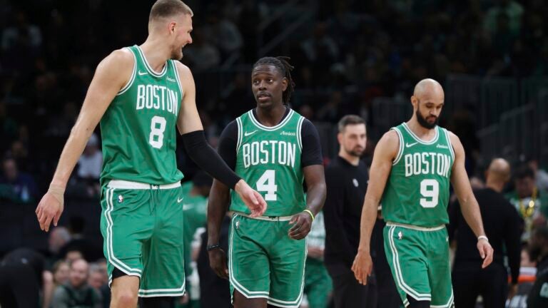Boston Celtics' Kristaps Porzingis (8), Jrue Holiday (4) and Derrick White (9) during the first half of an NBA basketball game against the New York Knicks Sunday, Feb. 23, 2025, in Boston.