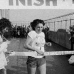 FILE - Nina Kuscsik, of Huntington, L.I., runs across finish line atop the Empire State Building Thursday, Feb. 14, 1980 in New York.