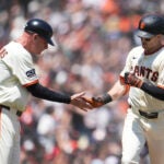 San Francisco Giants' Mike Yastrzemski, right, is congratulated by third base coach Matt Williams after hitting a home run during the fifth inning of a baseball game against the Boston Red Sox in San Francisco, Sunday, June 22, 2025.