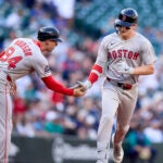 Boston Red Sox's Roman Anthony, right, is greeted by third base coach Kyle Hudson after hitting a solo home run off Seattle Mariners starting pitcher Logan Gilbert during the first inning of a baseball game Monday, June 16, 2025, in Seattle.