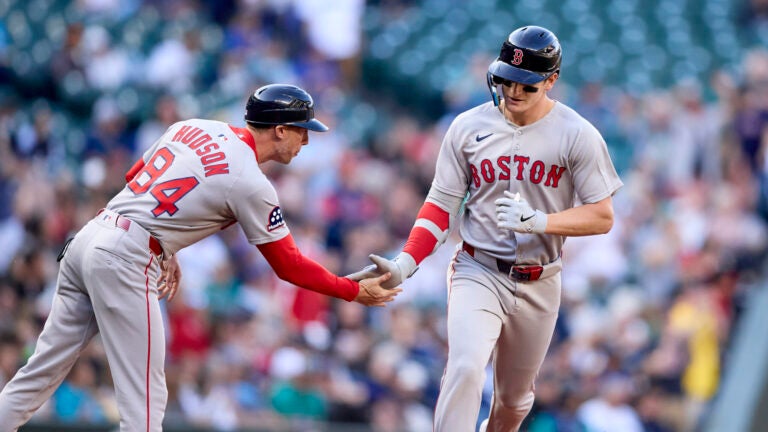 Boston Red Sox's Roman Anthony, right, is greeted by third base coach Kyle Hudson after hitting a solo home run off Seattle Mariners starting pitcher Logan Gilbert during the first inning of a baseball game Monday, June 16, 2025, in Seattle.
