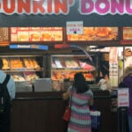 Customers line up inside one of two Dunkin' stalls at the Back Bay MBTA station location.