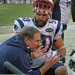 Patriots head coach Bill Belichick (left) talks to defenders Rob Ninkovich (50) and Andre Carter (right) in the second half. The New England Patriots visited the Washington Redskins in an NFL regular season game at FedEx Field.