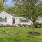 The home features a spacious front lawn and a one-car garage.