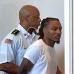 Gerald Vick (on the right) is escorted out of the courtroom in the Dorchester Division of Boston Municipal Court after he was arraigned in August of 2023.