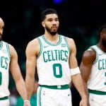 Boston Celtics guard Derrick White (9), forward Jayson Tatum (0) and guard Jaylen Brown (7) walk onto the court during the first quarter in game one of the second round of the NBA Eastern Conference playoffs at TD Garden.
