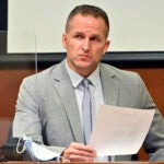 FILE - Former Louisville Police officer Brett Hankison examines a document as he answers questions from the prosecution, March 2, 2022, in Louisville, Ky.