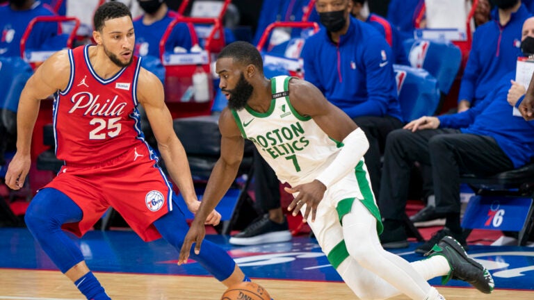 Boston Celtics' Jaylen Brown, right, drives to the basket against Philadelphia 76ers' Ben Simmons, left, during the first half of an NBA basketball game, Friday, Jan. 22, 2021, in Philadelphia.