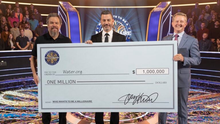 Matt Damon and Ken Jennings stand with "Who Wants to be a Millionaire" host Jimmy Kimmel after winning $1 million for charity.