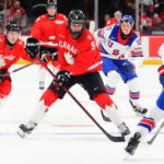 Canada's Gavin McKenna (9) skates with the puck as United States' Drew Fortescue (5) defends during the second period of an IIHF World Junior Hockey Championship tournament game in Ottawa, Ontario, Dec. 31, 2024.