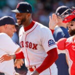 Boston Red Sox's Alex Cora, left, celebrates with relief pitcher Aroldis Chapman, center, after their team defeated the Tampa Bay Rays in a baseball game, Sunday, July 13, 2025, in Boston.