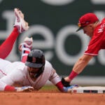 Trevor Story of the Red Sox is tagged out by Reds second baseman Matt McLain after over running the base on his RBI double during the eighth inning.