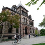 FILE - People traverse Brown University campus in Providence, R.I., Oct. 12, 2020.