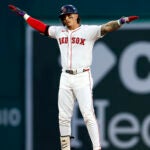 Jarren Duran stands with arms outstretched at second base after a double.