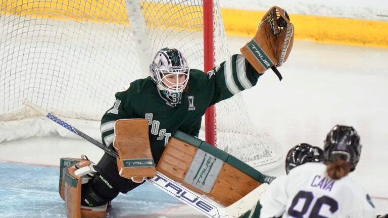 Boston goalie Aerin Frankel, left, grabs the puck for a save in front of Minnesota forward Michela Cava, right, during the third period of Game 1 of a PWHL hockey championship series, Sunday, May 19, 2024, in Lowell, Mass.