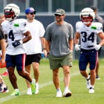 Former New England Patriots wide receiver Julian Edelman (second from right) walks on the field during NFL training camp at Gillette Stadium on Aug. 4, 2025.