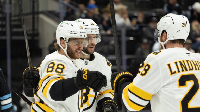 Boston Bruins right wing David Pastrnak (88), center Pavel Zacha (18) and center Elias Lindholm (28) celebrate after a goal against the Utah Mammoth during the first period of an NHL hockey game Sunday, Oct. 19, 2025, in Salt Lake City.