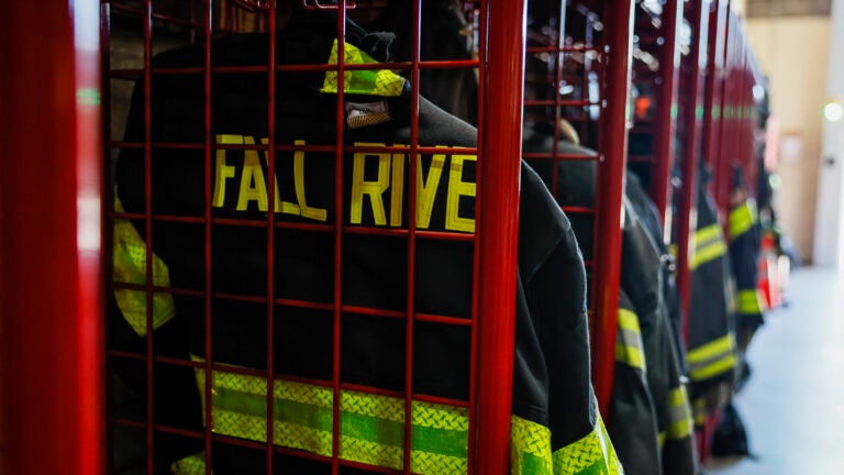 Firefighting gear hangs in red lockers at the Fall River Fire Department station.