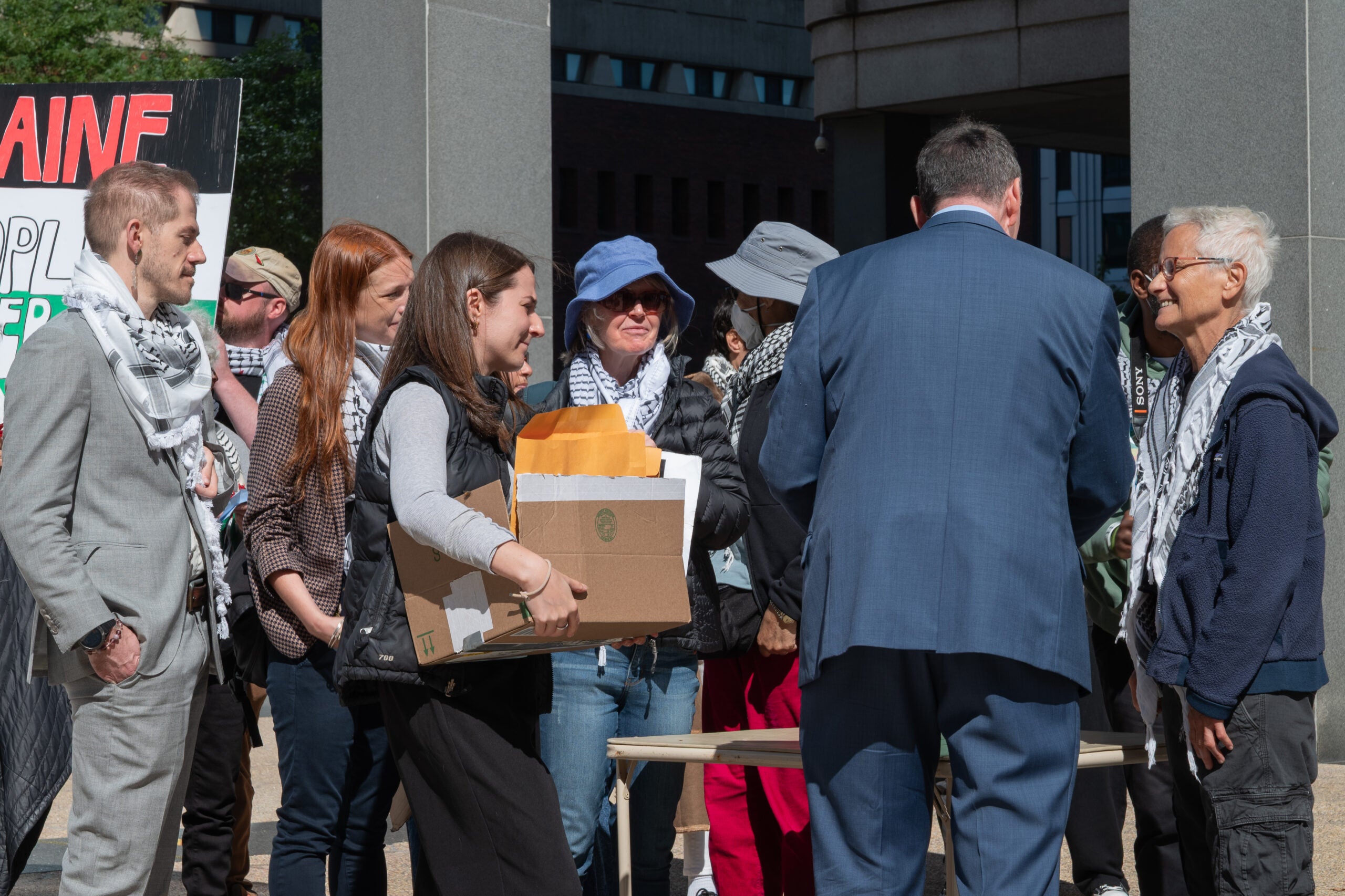 Rally attendees prepare to deliver letters to Sen. Ed Markey and Sen. Elizabeth Warren.