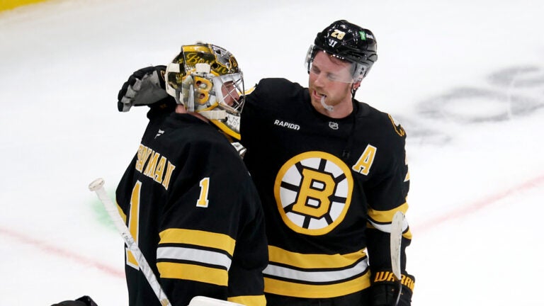 Bruins goalie Jeremy Swayman, left, is congratulated by teammate Bruins forward Elias Lindholm after beating the Sabres at TD Garden on Saturday, October 11, 2025.