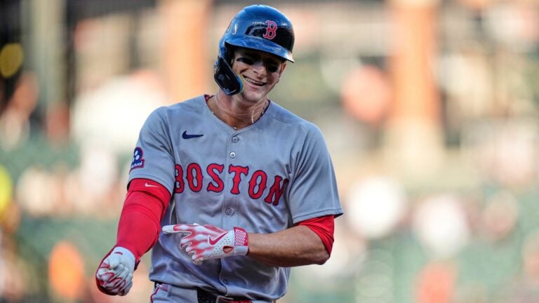 Roman Anthony smiles as he points to his arm whle rounding the bases during a game.