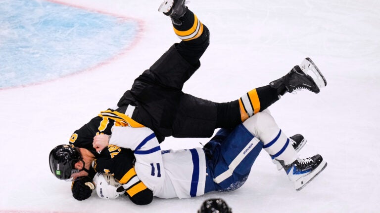 Boston Bruins defenseman Nikita Zadorov, top, drops Toronto Maple Leafs center Max Domi (11) to the ice during the third period of an NHL hockey game, Tuesday, Nov. 11, 2025, in Boston.