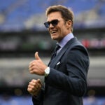 Fox broadcaster and former NFL quarterback Tom Brady gives a thumbs up before an NFL football game between the Baltimore Ravens and the Los Angeles Rams, Sunday, Oct. 12, 2025, in Baltimore.
