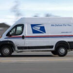 A United States Postal Service truck drives through Detroit.