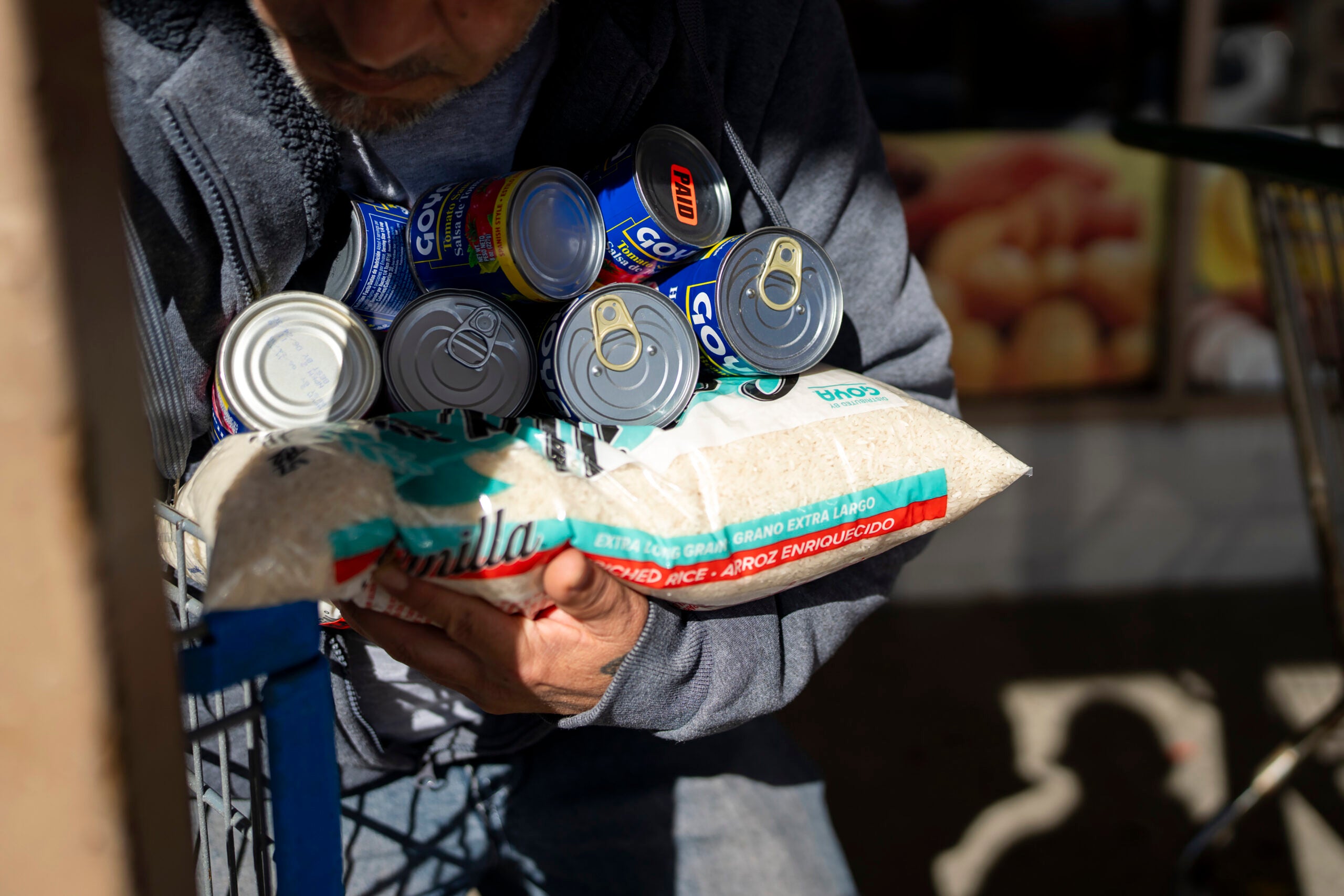 A man carries groceries to their car outside America’s Food Basket in Springfield, Mass.