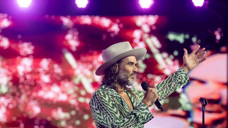 Russell Brand speaks during Turning Point USA's AmericaFest 2025.