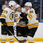 Boston Bruins' Marat Khusnutdinov (92) celebrates with David Pastrnak (88) and Charlie McAvoy (73) after scoring a goal during the third period of an NHL hockey game against the New York Islanders Tuesday, Nov. 4, 2025, at UBS Arena in Elmont, N.Y.