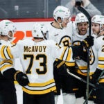 Boston Bruins players celebrate Elias Lindholm's (28) goal against the Winnipeg Jets during the third period of of an NHL hockey game, in Winnipeg, Manitoba, Thursday, Dec. 11, 2025.