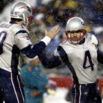 Patriots placekicker Adam Vinatieri (right) connected in the snow with his first field goal try with his new holder, quarterback Damon Huard (left), who gives him five after the kick gave New England all the points it would need, putting the Patriots ahead 3-0, on the way to a 12-0 AFC East clinching victory over the Miami Dolphins at Gillette Stadium.